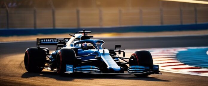 A bald man with a gray beard, wearing a blue shirt, stands in front of a gray background.