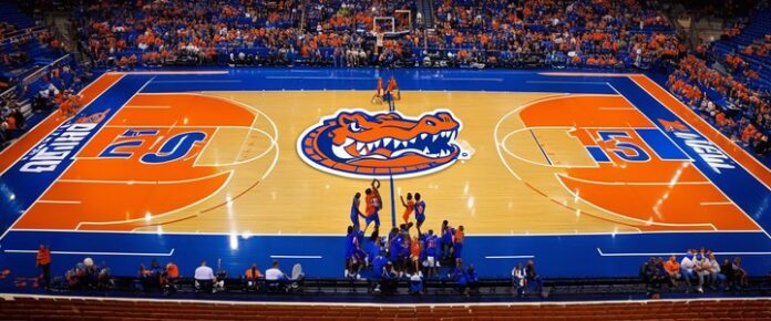 A basketball court with a crowd of people, featuring an orange and blue color scheme.