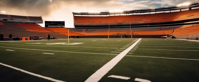 A football field with goalposts in an empty stadium under cloudy skies.