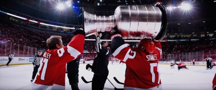 Hockey players collide on ice during Stanley Cup playoff game.
