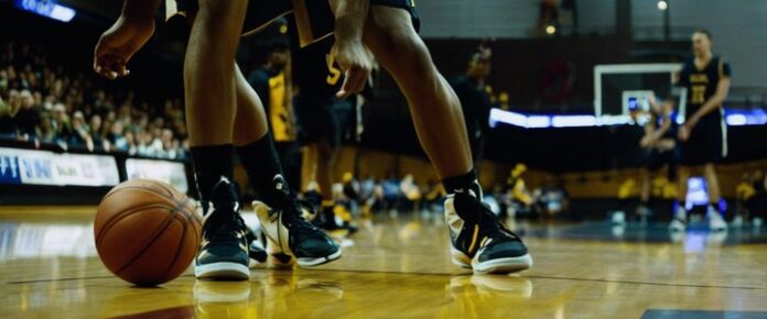 Malik Thomas in action on the basketball court, scoring a shot.