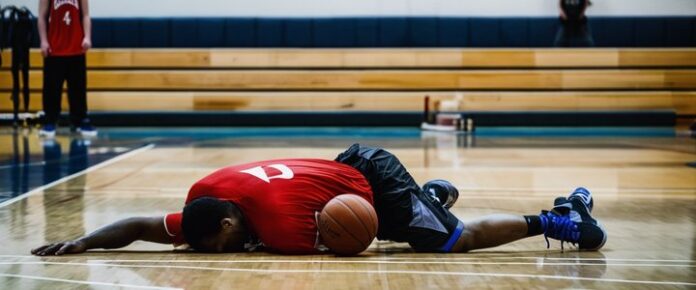 Stephen Curry sitting on bench, holding injured leg.